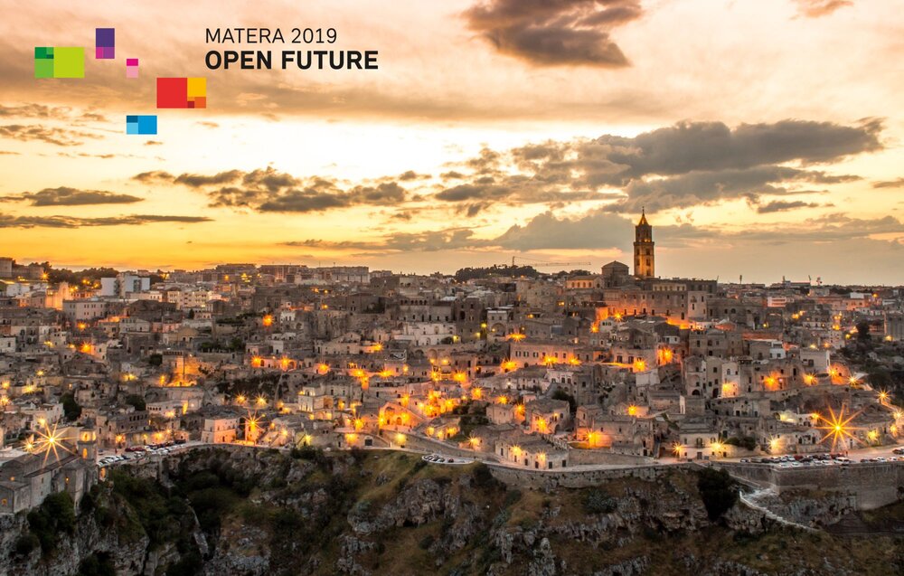 Panoramic view of Sassi di Matera at sunset with the Matera 2019 logo